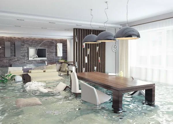 Homeowner documenting water damage with a phone before cleanup begins